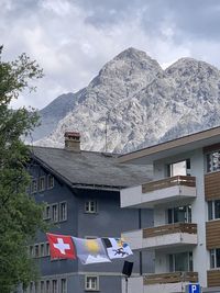 Buildings by mountains against sky