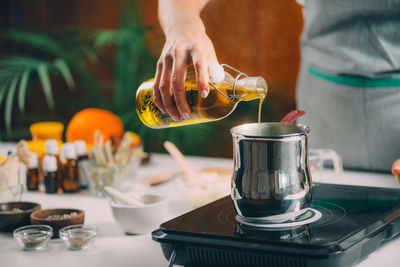 Pouring natural oil, making homemade soap.