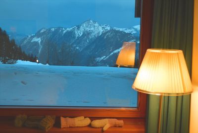 Illuminated lamp on snowcapped mountains during winter