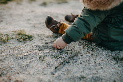 Rear view of boy lying on land