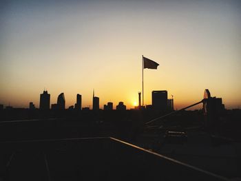 Silhouette city against sky during sunset