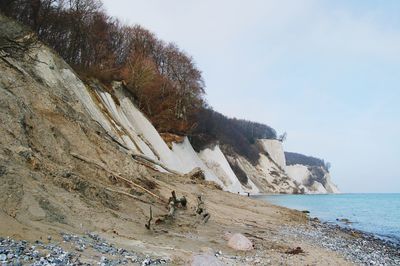 Scenic view of cliff by sea against sky at jasmund national park