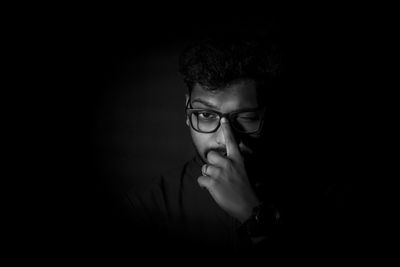 Portrait of young man against black background