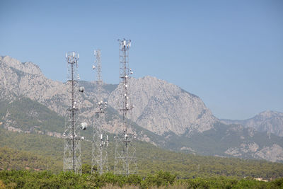 Electricity pylon on mountain against sky