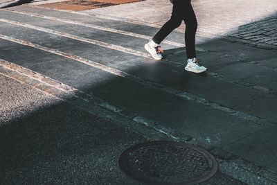 Low section of woman standing on road