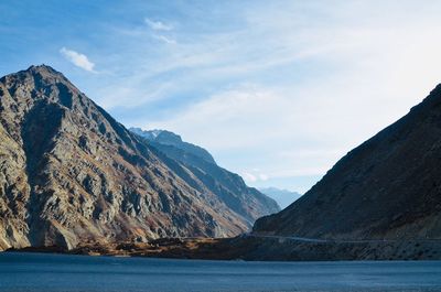 Scenic view of lake by mountains against sky