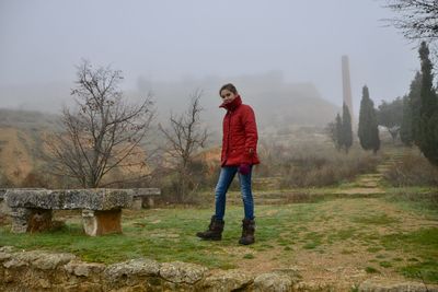 Portrait of girl standing against sky during foggy weather