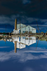 Reflection of built structure in lake against sky