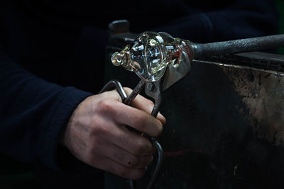 Close-up of hands cutting glass in factory