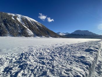 Scenic view of snowcapped mountains against blue sky