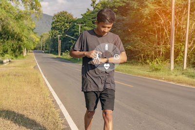 Full length portrait of man standing on road