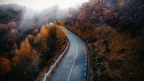 Road amidst trees during autumn