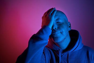 Side view of man standing against blue background