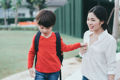 Boy and woman with arms raised