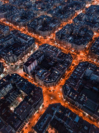 Aerial view of illuminated street amidst buildings in city