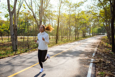 Smiling woman jogging on road