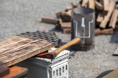 High angle view of cutting board and axe on containers at field