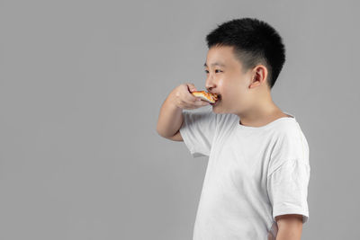 Full length of a boy looking over white background