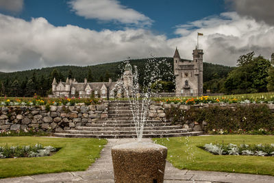 Fountain in front of built structure against sky