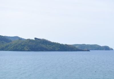 Scenic view of sea and mountains against clear sky