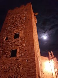 Low angle view of illuminated building against sky at night