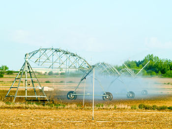 Ferris wheel on field against sky