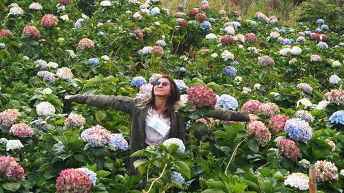 Portrait of woman standing amidst flowers