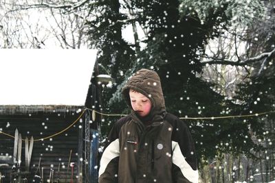 Portrait of woman standing by tree during winter