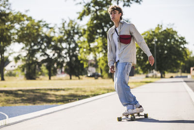 Young man skateboarding on sunny day