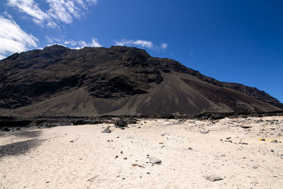 Scenic view of mountains against blue sky