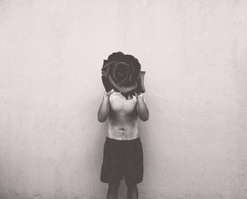 Full length of shirtless man standing against white background