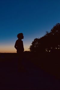 Silhouette man standing against clear sky during sunset