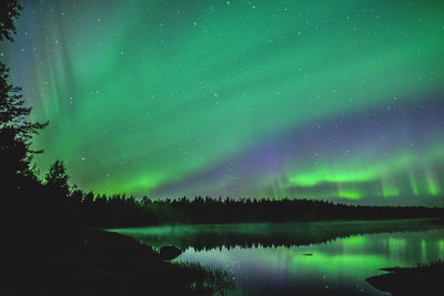 Aurora borealis reflecting in lake at night