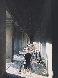 Full length of boy standing in corridor