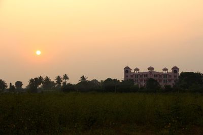 Scenic view of grassy field against sky during sunset