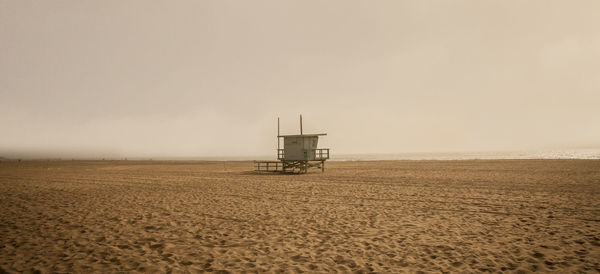 Lifeguard hut on beach against sky