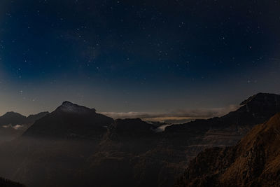Scenic view of mountains against sky at night