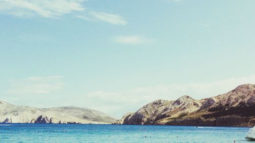 Scenic view of sea and mountains against sky