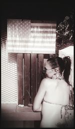 Young woman standing by window