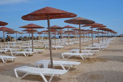 Lounge chairs and parasols on sand at beach