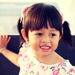 Close-up of smiling girl looking away while standing outdoors