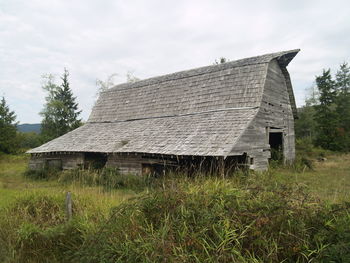 Old house on field against sky