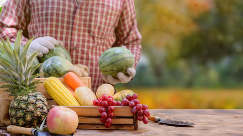 Full length of man holding fruit while standing outdoors