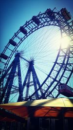 Low angle view of ferris wheel against blue sky