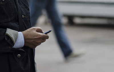 Midsection of man using mobile phone