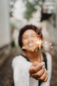 Midsection of woman holding sparkler