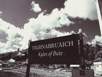 Low angle view of sign board against sky