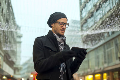 Young man using mobile phone in winter