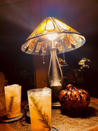 Close-up of illuminated candles on glass table