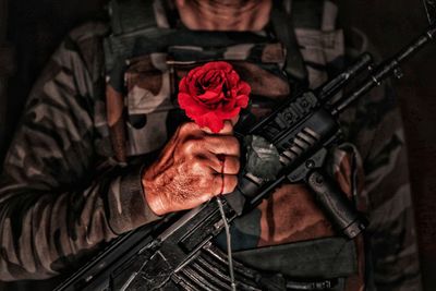 Midsection of man holding red roses